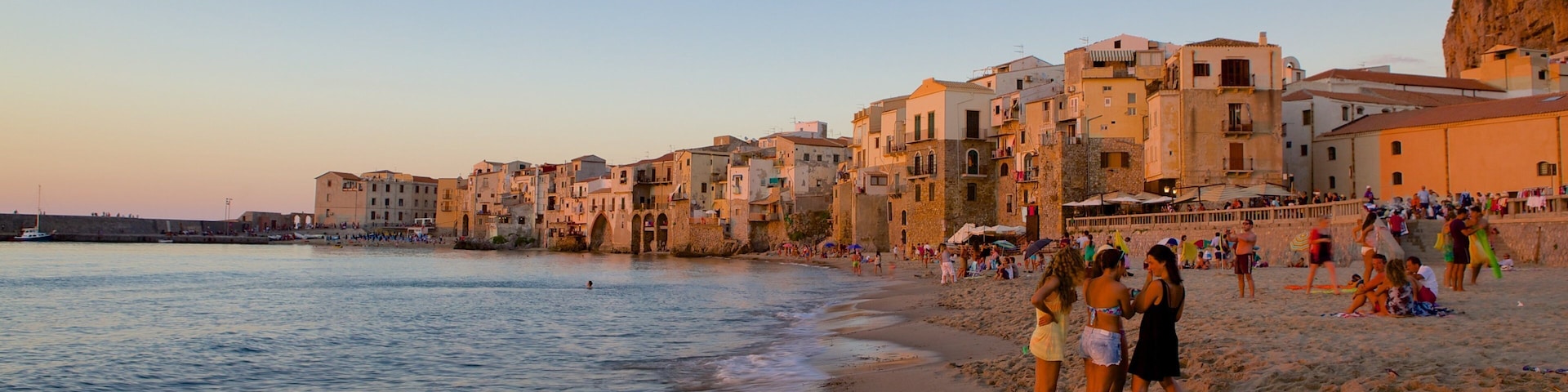 Rocca of Cefalu which includes a coastal town and a beach as well as a small group of people