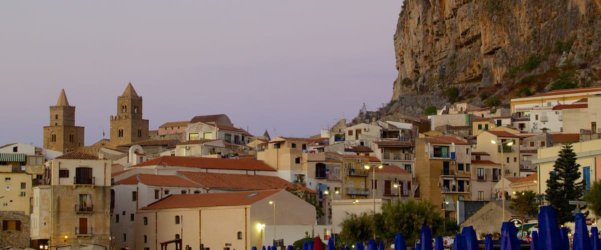 Roca de Cefalú que incluye una pequeña ciudad o pueblo y una puesta de sol