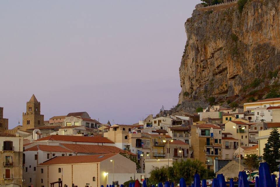 A coastal town with historic buildings, a prominent church, and a steep cliff.