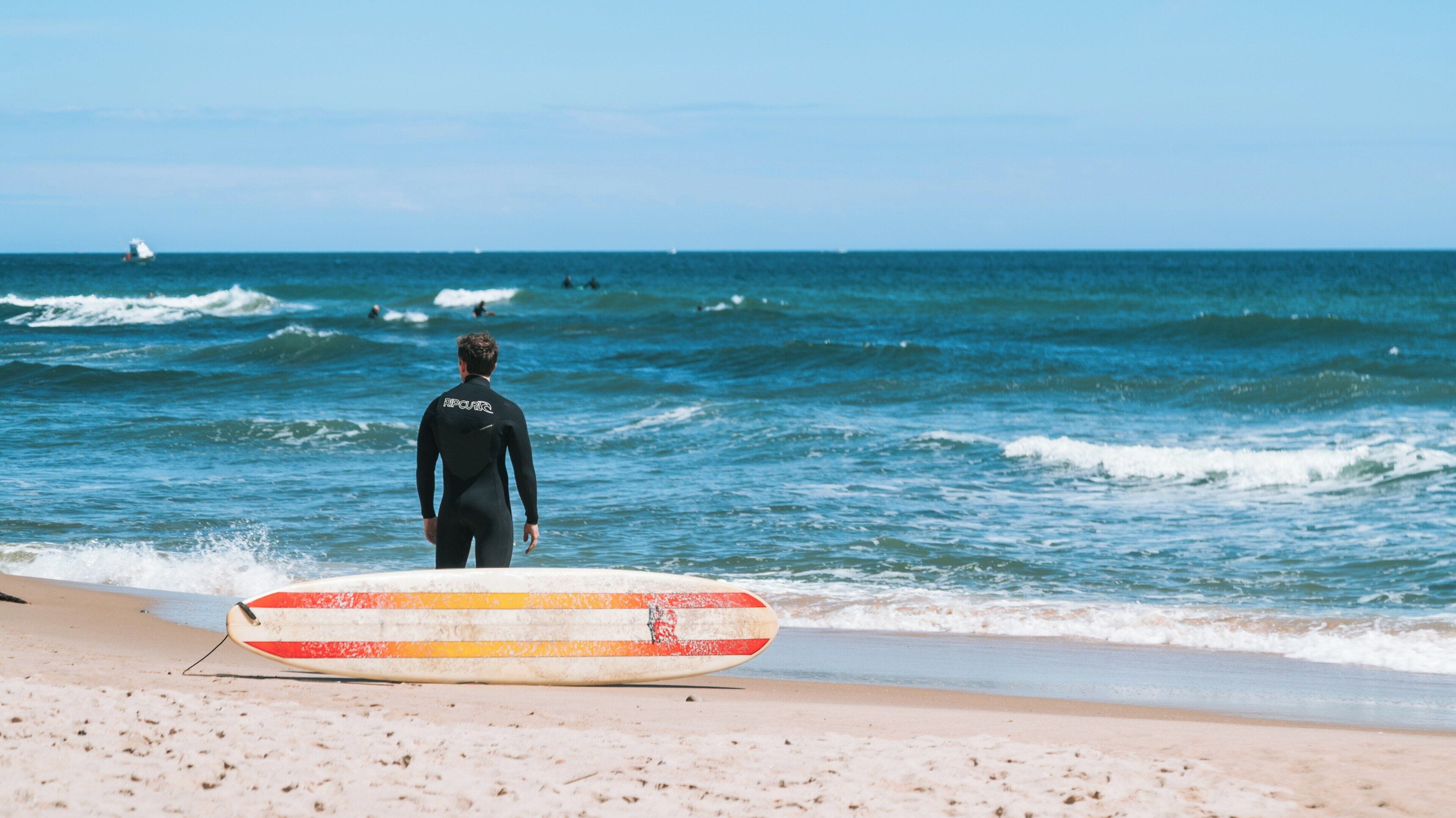 Surfer awaits perfect waves at Ditch Plains Beach in Montauk, New York on a sunny day