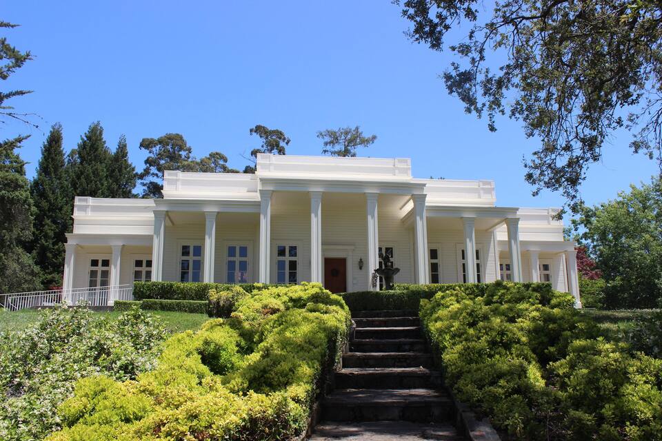 A large white building with columns and a staircase leading up to the entrance.