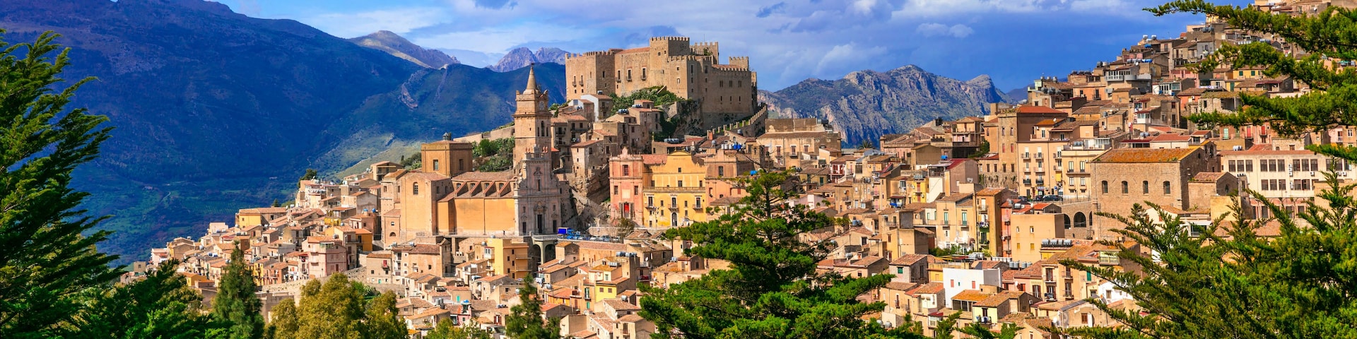 A mountainous town with historic architecture and a prominent castle.