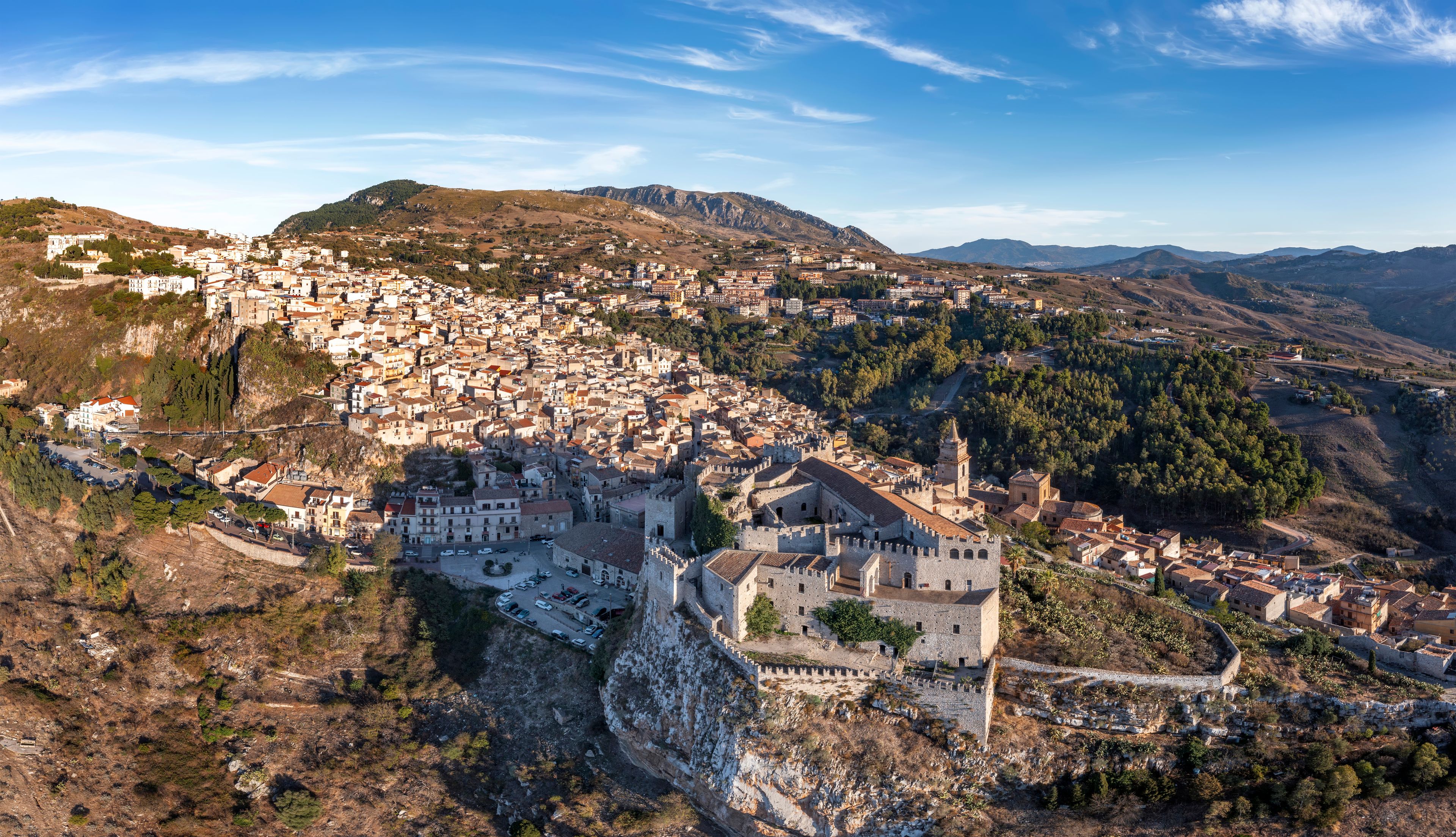 A mountainous town with a prominent castle and dense residential area.