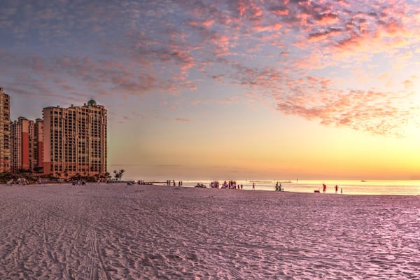 A beach with high-rise buildings and a sunset.