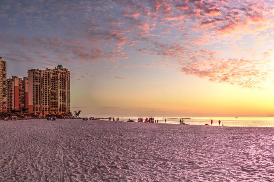A beach with high-rise buildings and a sunset.