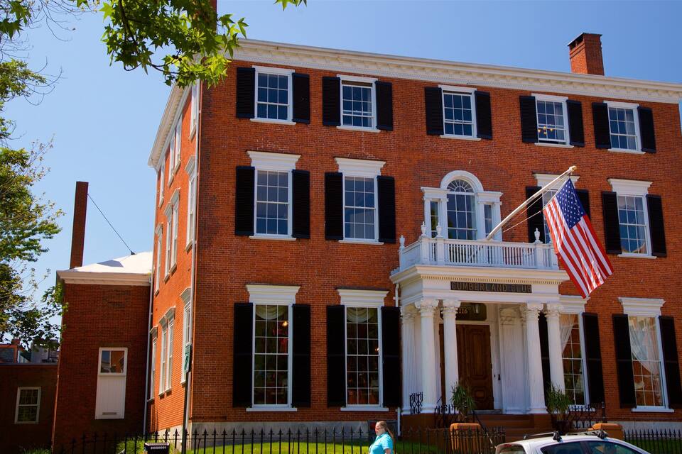 Un edificio di mattoni di due piani con un balcone e una bandiera americana.