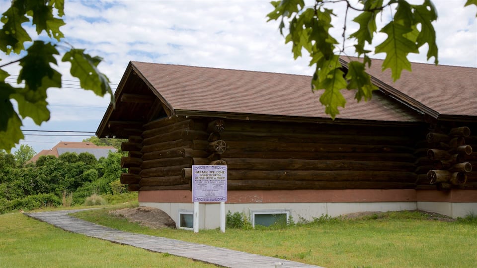 A wooden log cabin with a signboard.