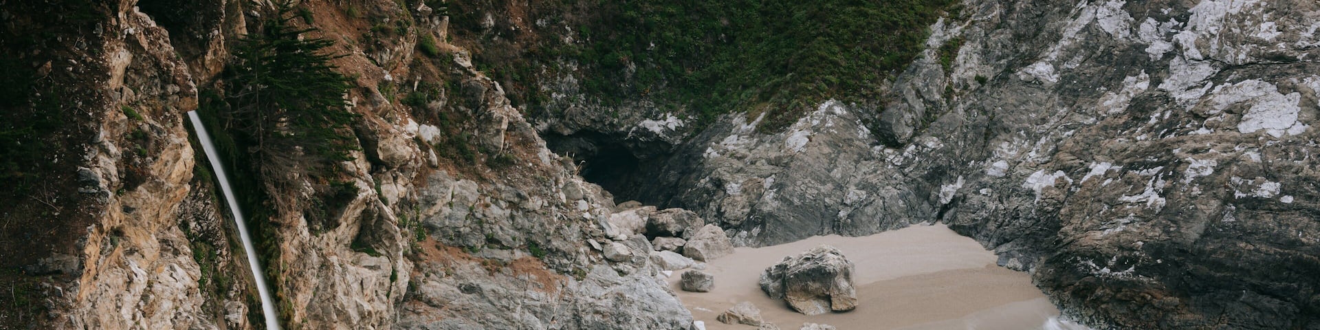 McWay Falls featuring rugged coastline, a waterfall and a sandy beach