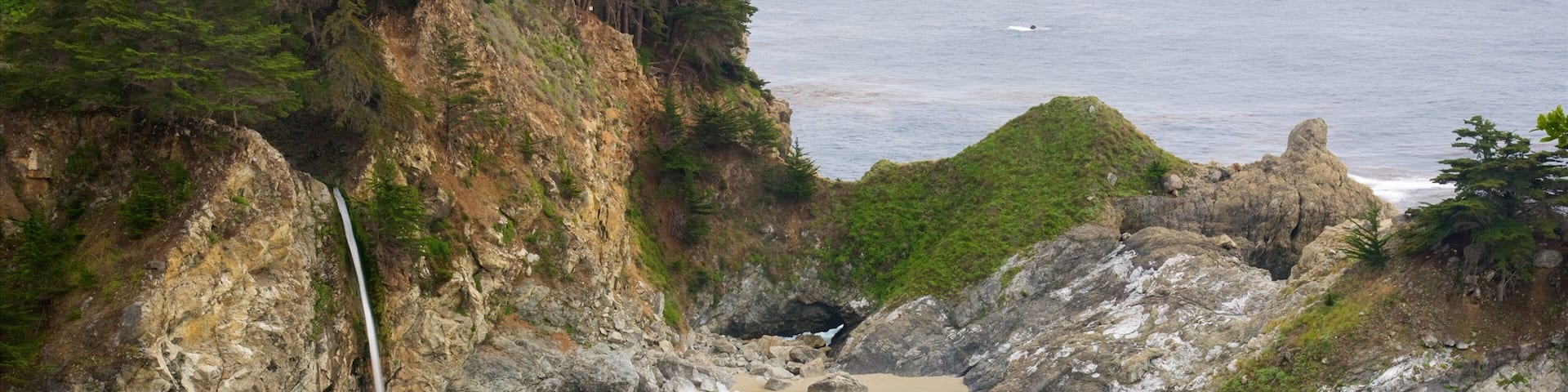 McWay Falls featuring a bay or harbour, a sandy beach and rocky coastline