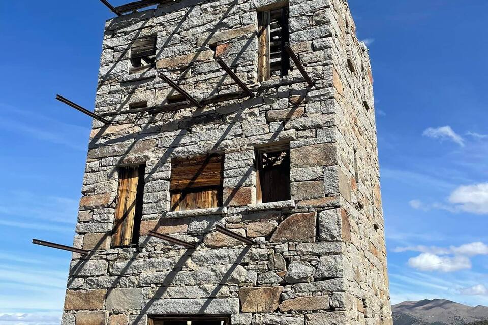 A stone tower with wooden beams and windows.