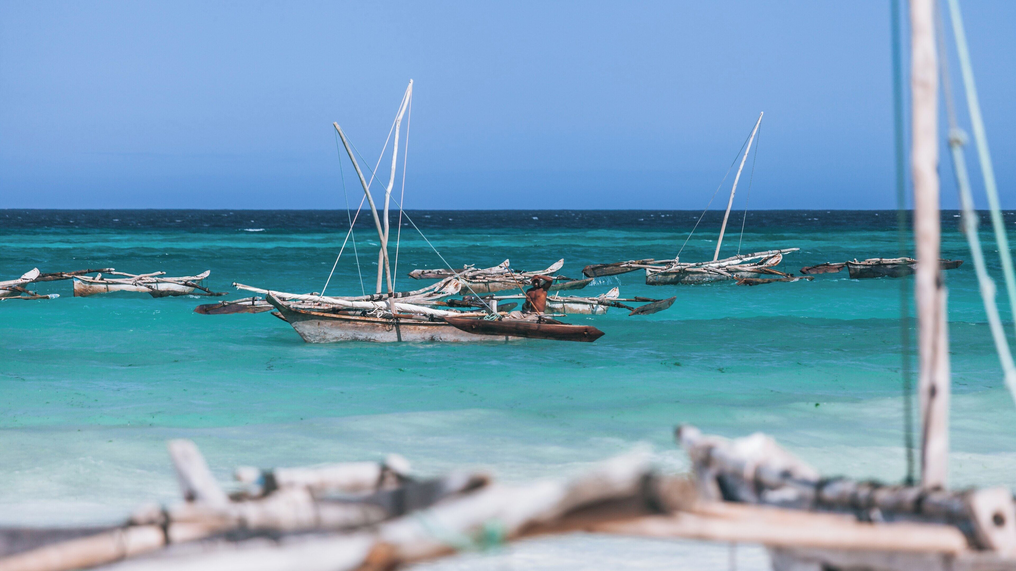 Beautiful Muyuni Beach in Matemwe, Tanzania with traditional dhows anchored on turquoise waters during a sunny day