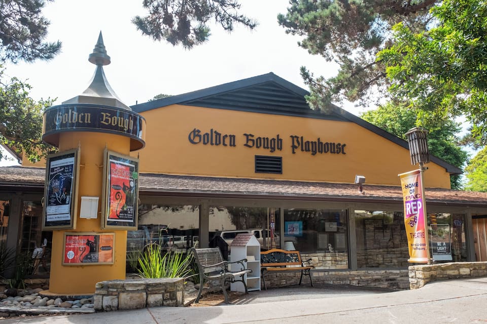 The exterior of the Golden Bough Playhouse, featuring a yellow facade, a pointed roof, and a marquee sign.