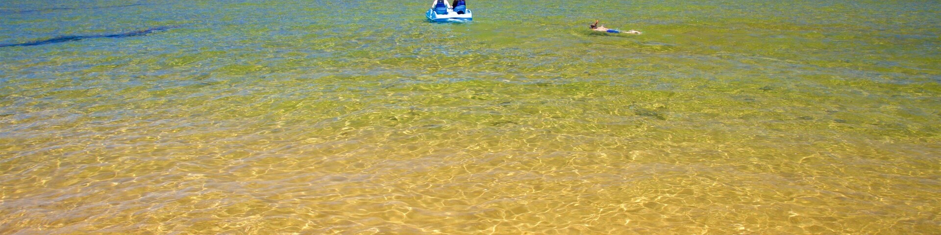 Playa Pope que incluye una playa de arena, un lago o laguna y piragüismo