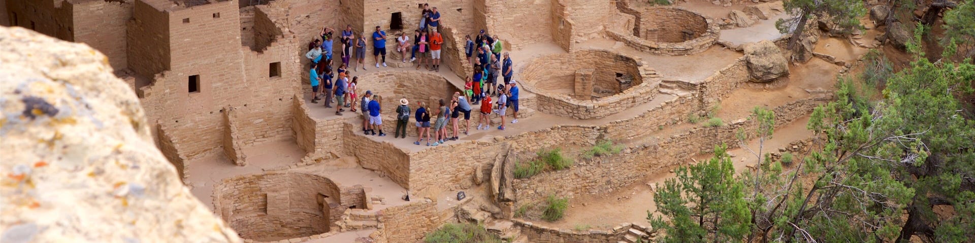 Cliff Palace showing a ruin and heritage architecture as well as a small group of people