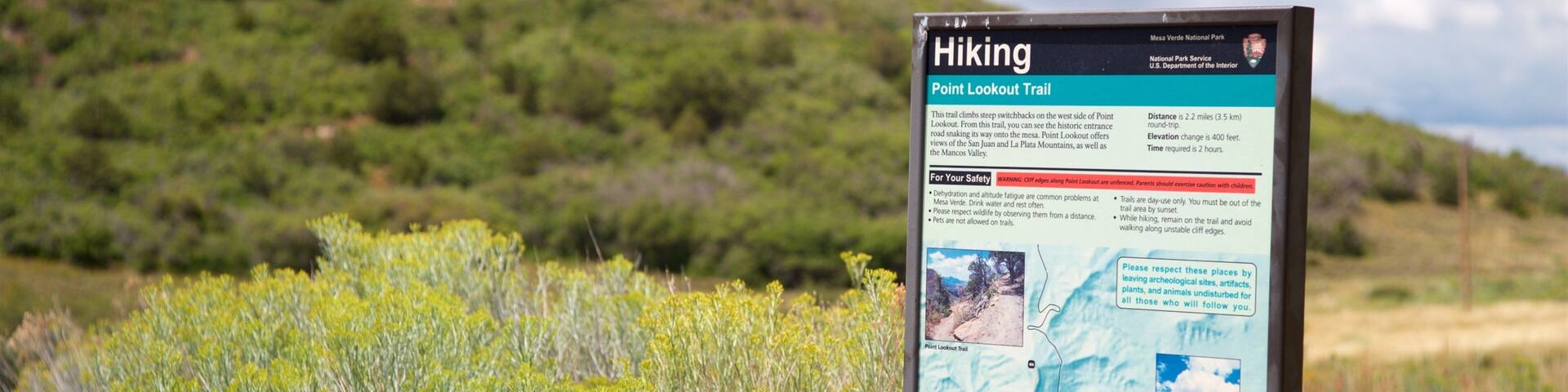 A hiking sign with a map and information about the Point Lookout Trail.