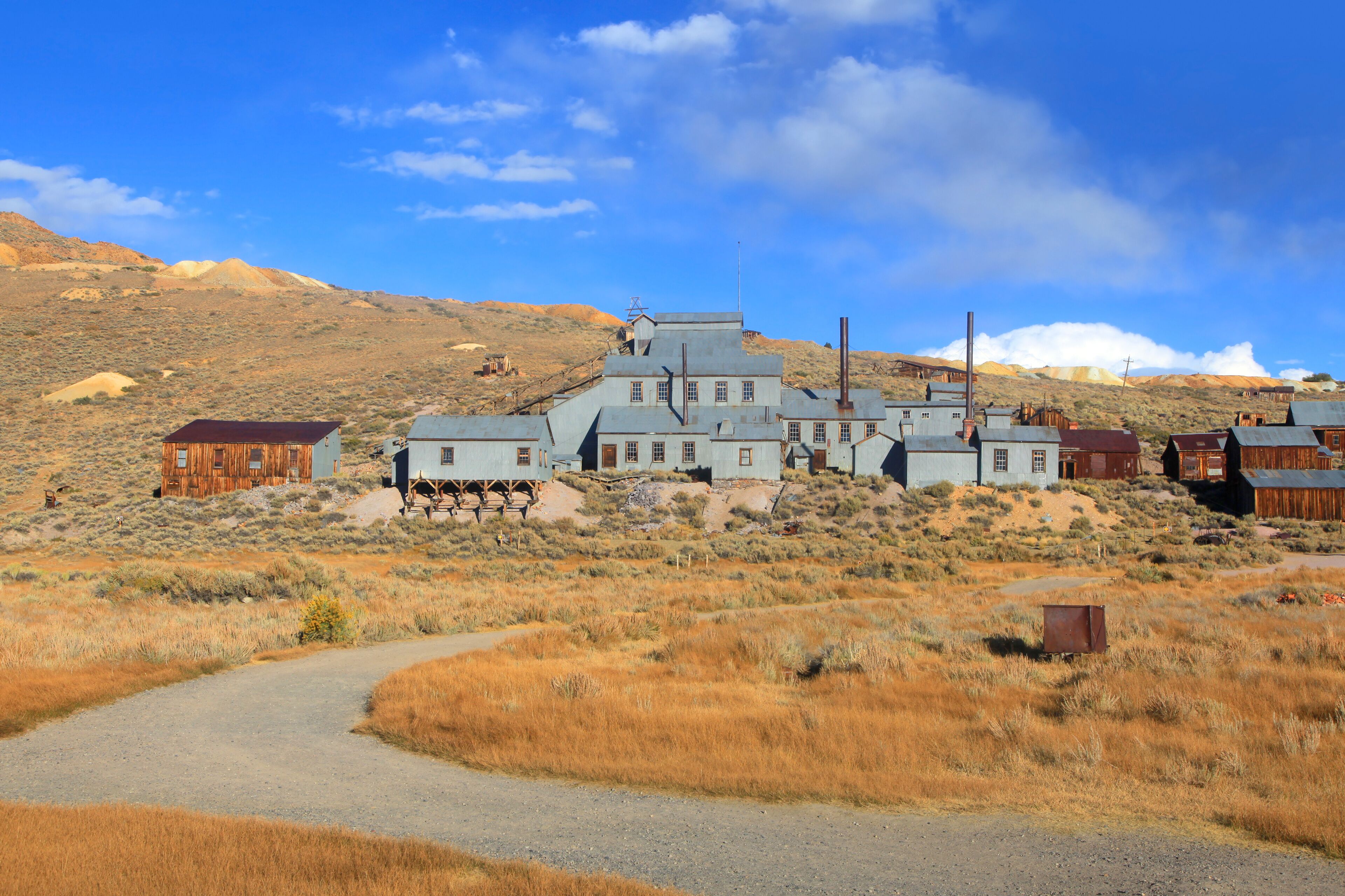 A historic mining town with buildings and a dirt road.