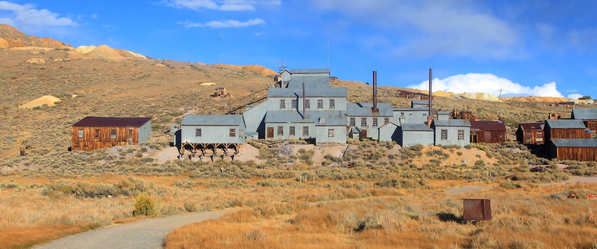 A historic mining town with buildings and a dirt road.