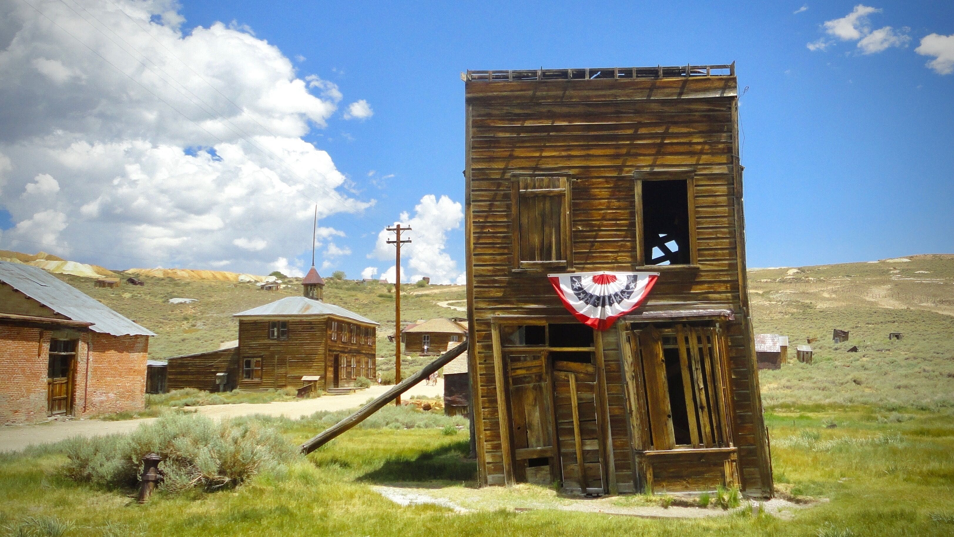 Bodie is the most realistic western ghost town in California. The remaining buildings remain as they were abandoned and the park is in a state of natural decay. Furniture, medical products of the time, and stocked goods within the buildings remain in place as they were in the gold rush era. It's almost as if everyone left the town at once without looking back. To add to the mystique, The roads change to dirt as one approaches the town. 
#History

Bodie was a gold mining town that boomed to 10,000 persons at its hight in the late 1800s. After editing and posting this photo, I became interested in revisiting and experiencing the summer nighttime ghost tours.