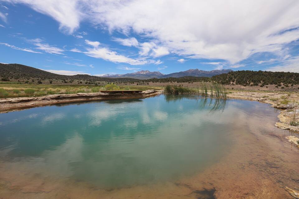 Un lago sereno con montañas al fondo.