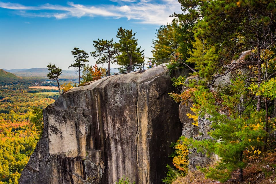 A large rock formation with trees around it.