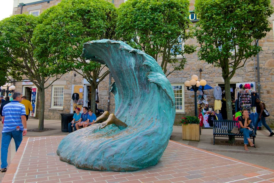 A large bronze sculpture of a wave in an outdoor public space.