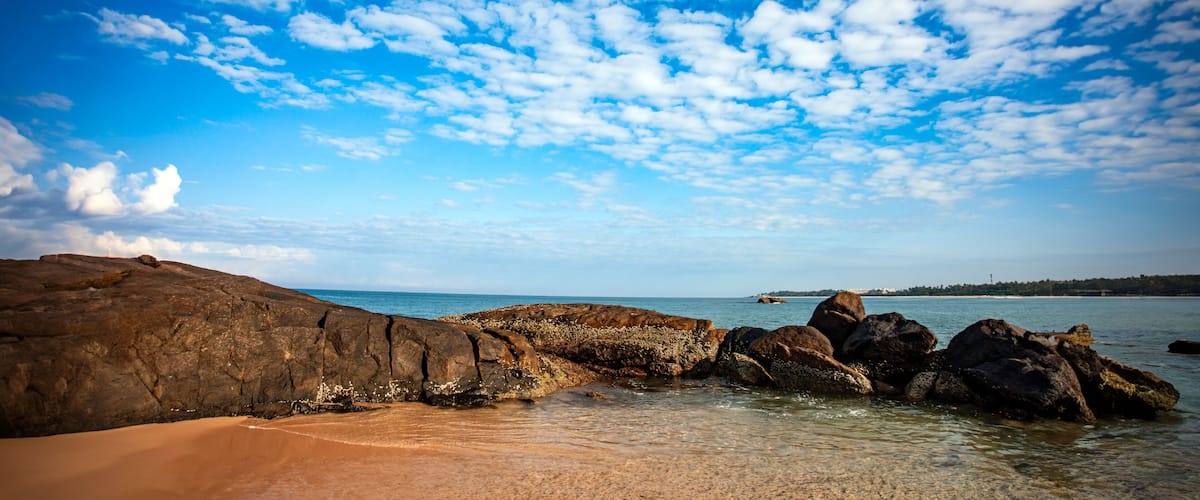 sea and rocks with white clouds in the blue sky of southern Sri Lanka beach.