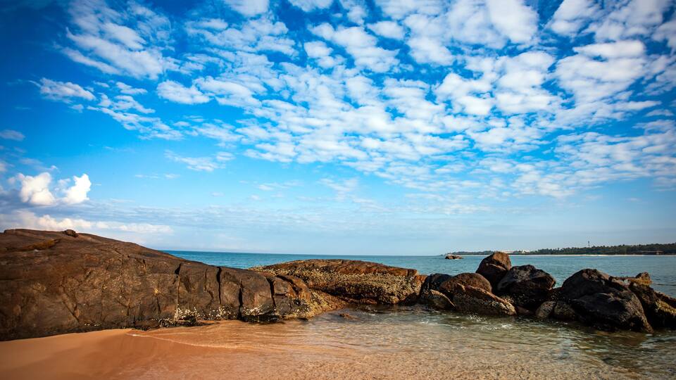 sea and rocks with white clouds in the blue sky of southern Sri Lanka beach.