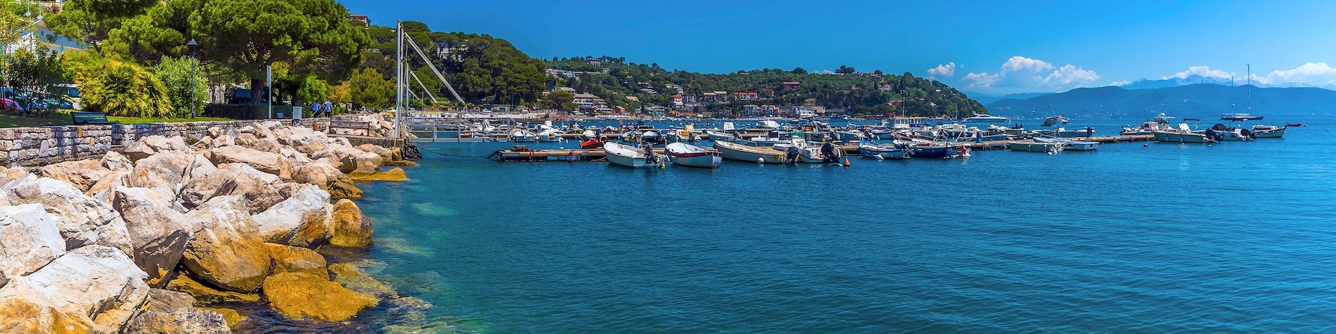 Rock armour lines the shore of a marina in Porto Venere, Italy in the summertime