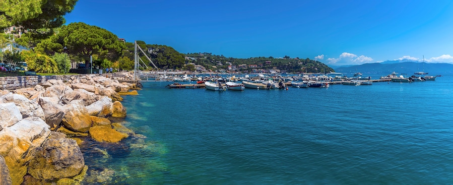 Rock armour lines the shore of a marina in Porto Venere, Italy in the summertime