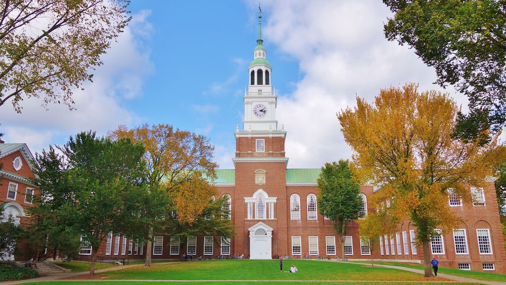 Looking down the Dartmouth Green with trees beginning to show fall colors and a blue sky with puffy white clouds on a nice autumn day the Baker Library and its bell tower is in the background.; Shutte