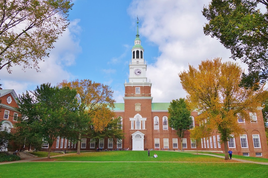 Looking down the Dartmouth Green with trees beginning to show fall colors and a blue sky with puffy white clouds on a nice autumn day the Baker Library and its bell tower is in the background.; Shutte