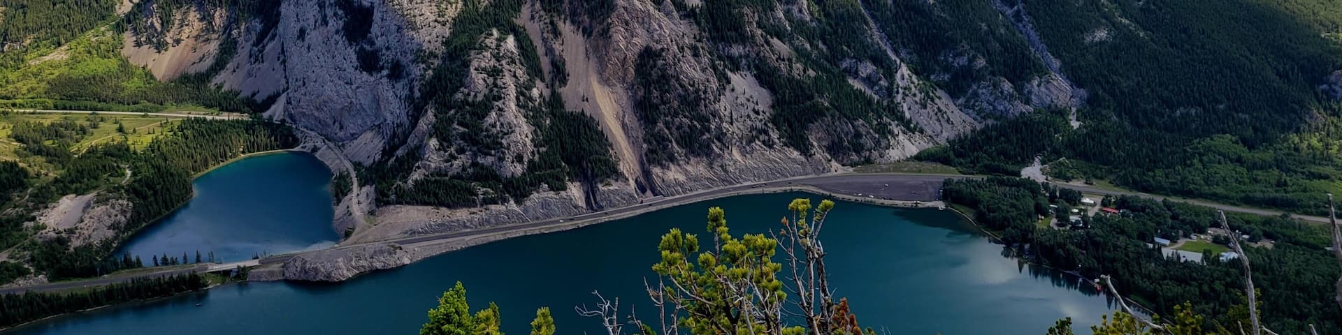 A mountain with a lake at its base, surrounded by forested hills.