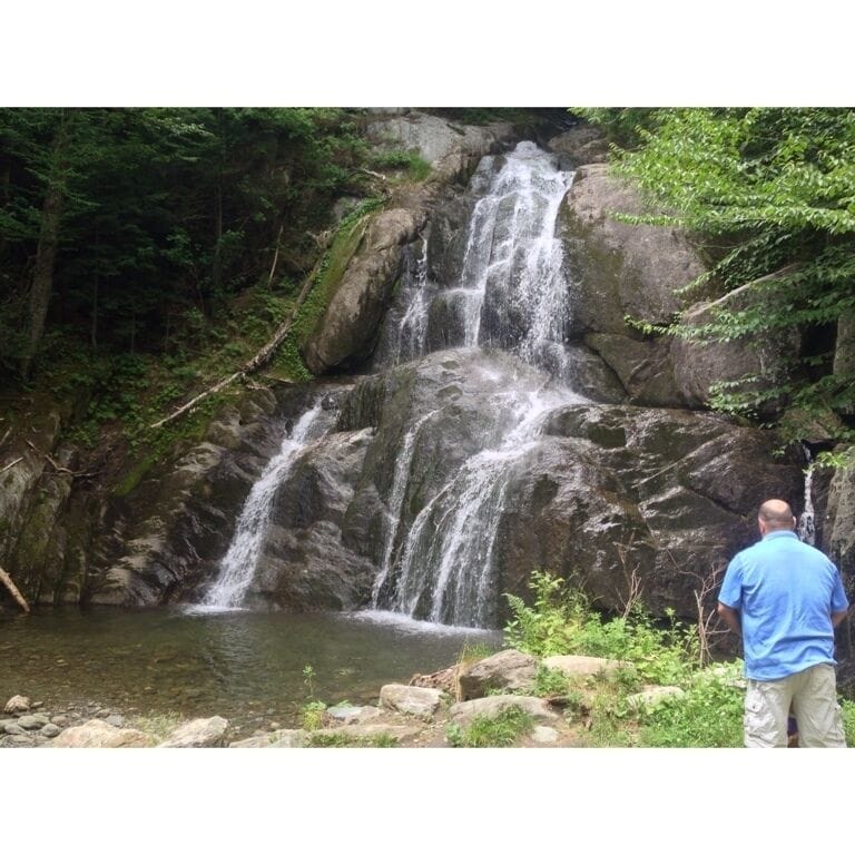 A waterfall cascading over rocks in a forested area.