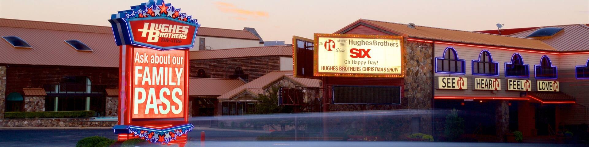 A Hugh's Brothers Theatre with a 'Family Pass' sign and a 'Six' Christmas show poster.