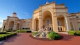 A grand building with arched windows and a central fountain.