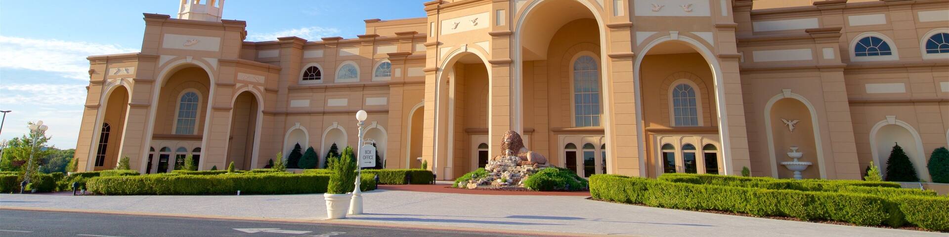 A large, beige-colored building with a prominent dome and arched windows.