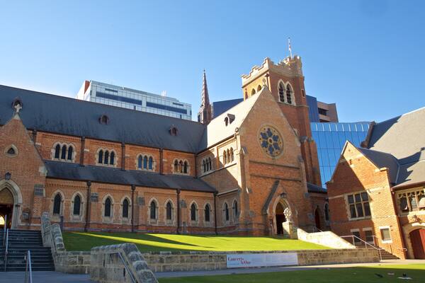 A historic church with a clock tower and a modern building in the background.