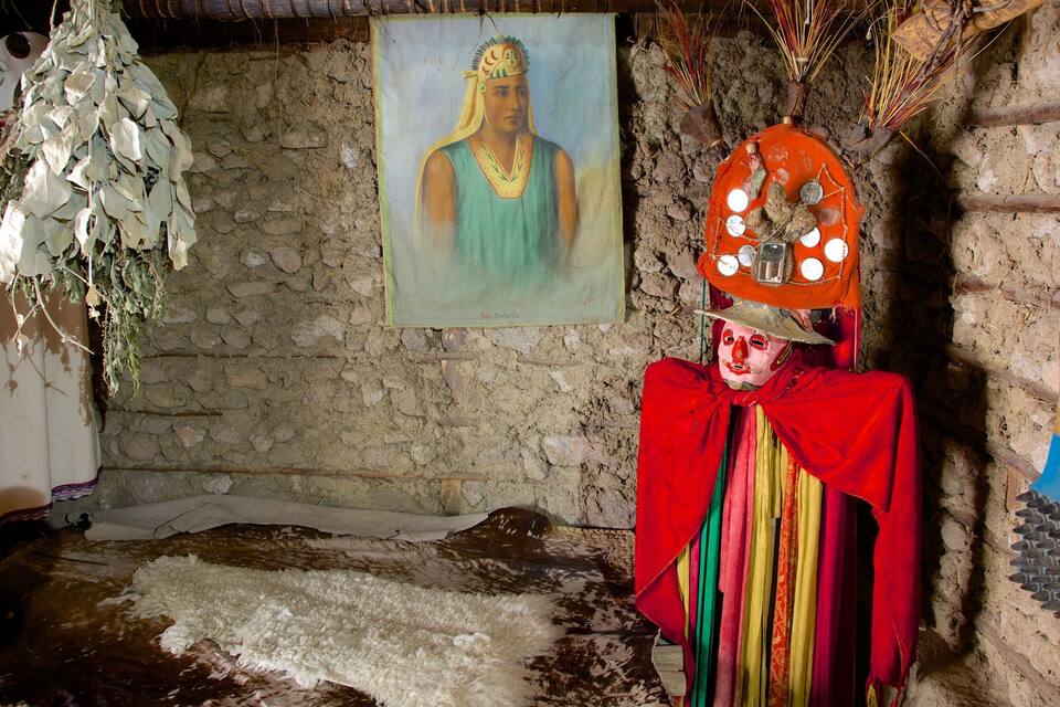 A traditional mask, a painting, and a rustic interior.