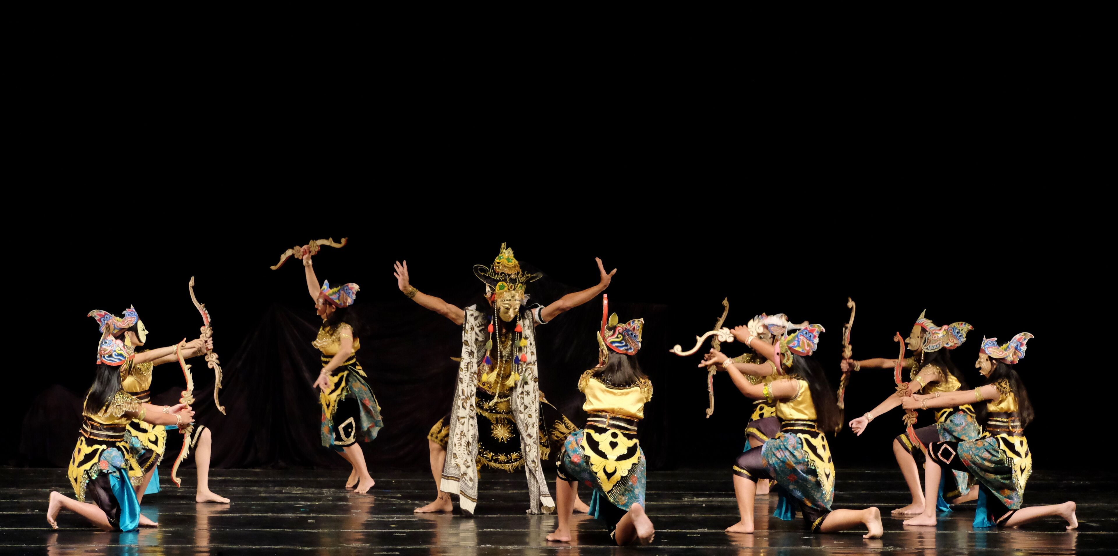 A group of dancers in traditional costumes performing on a stage.