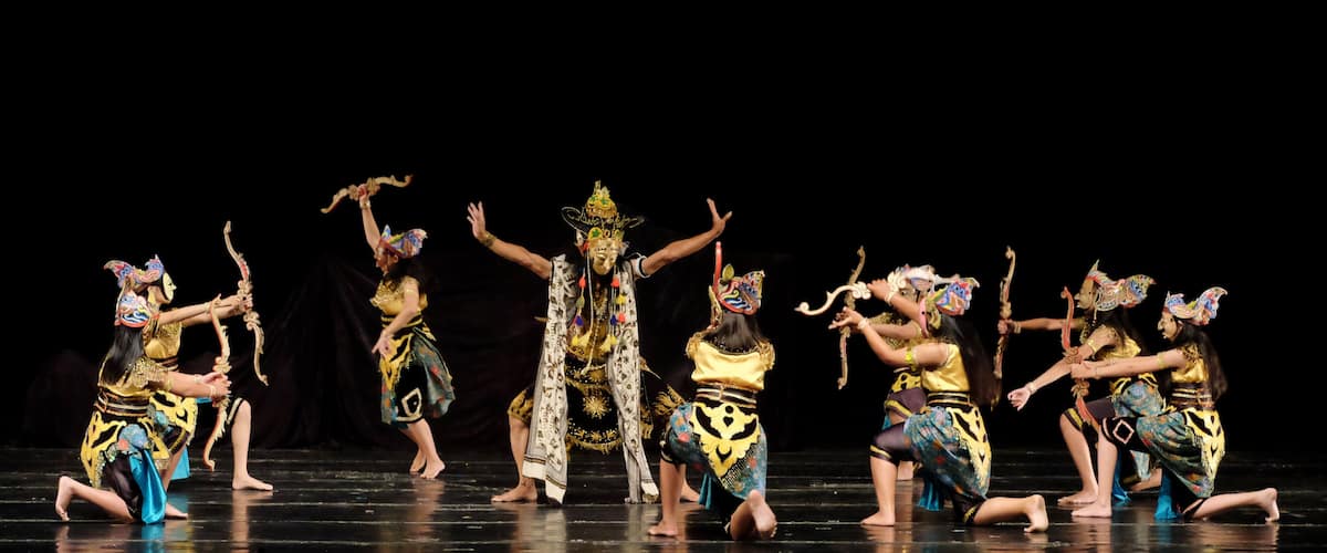 A group of dancers in traditional costumes performing on a stage.