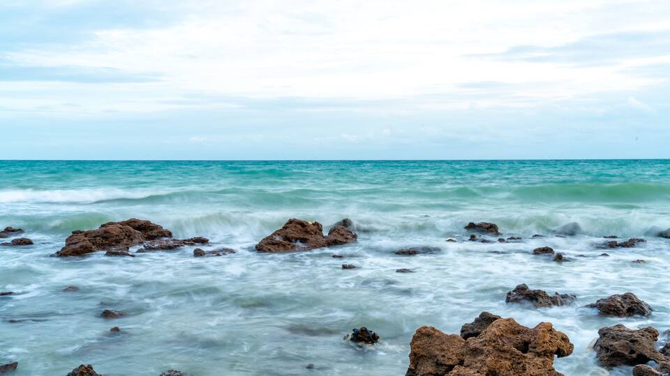 A rocky shoreline with waves crashing against the rocks.
