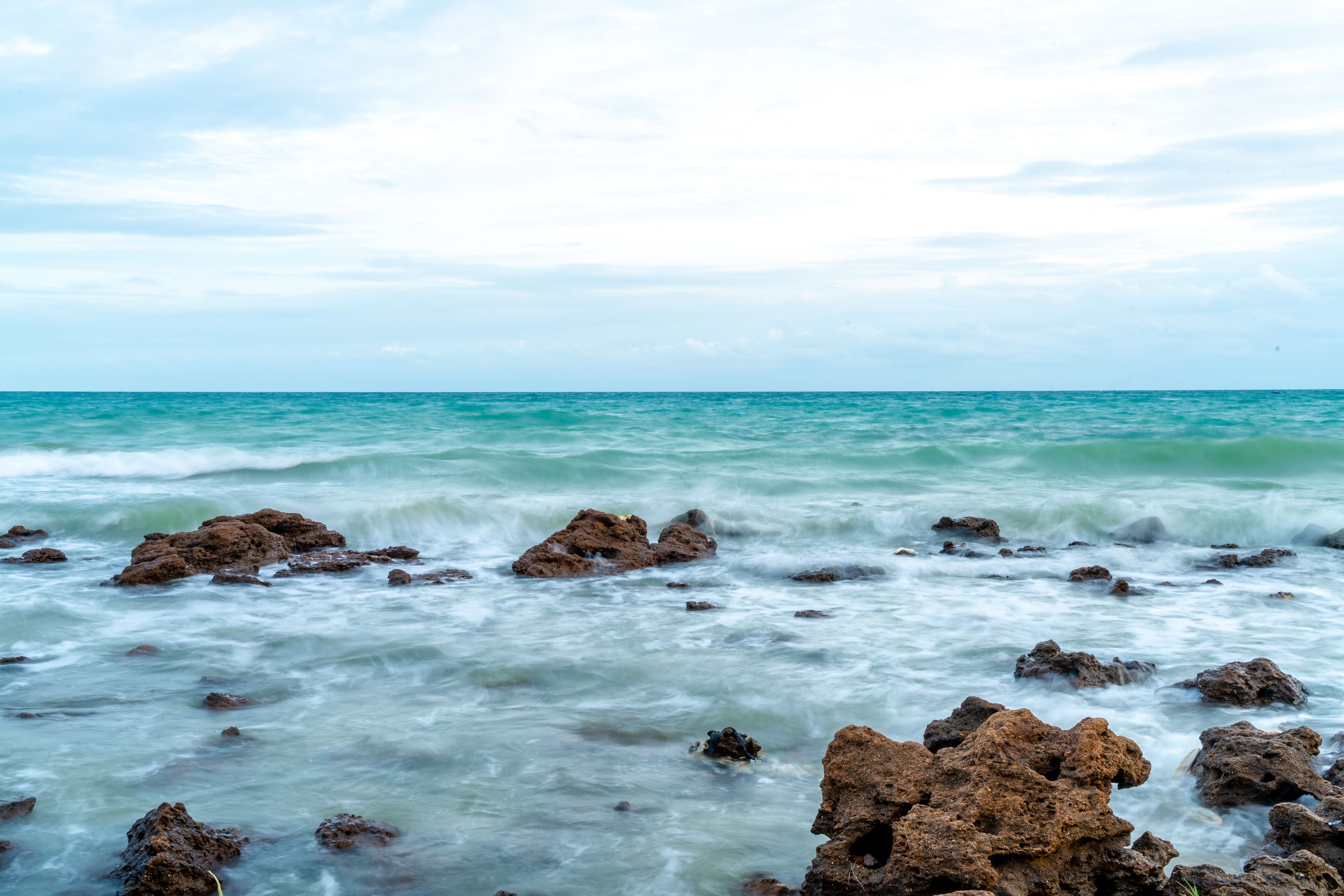 A rocky shoreline with waves crashing against the rocks.