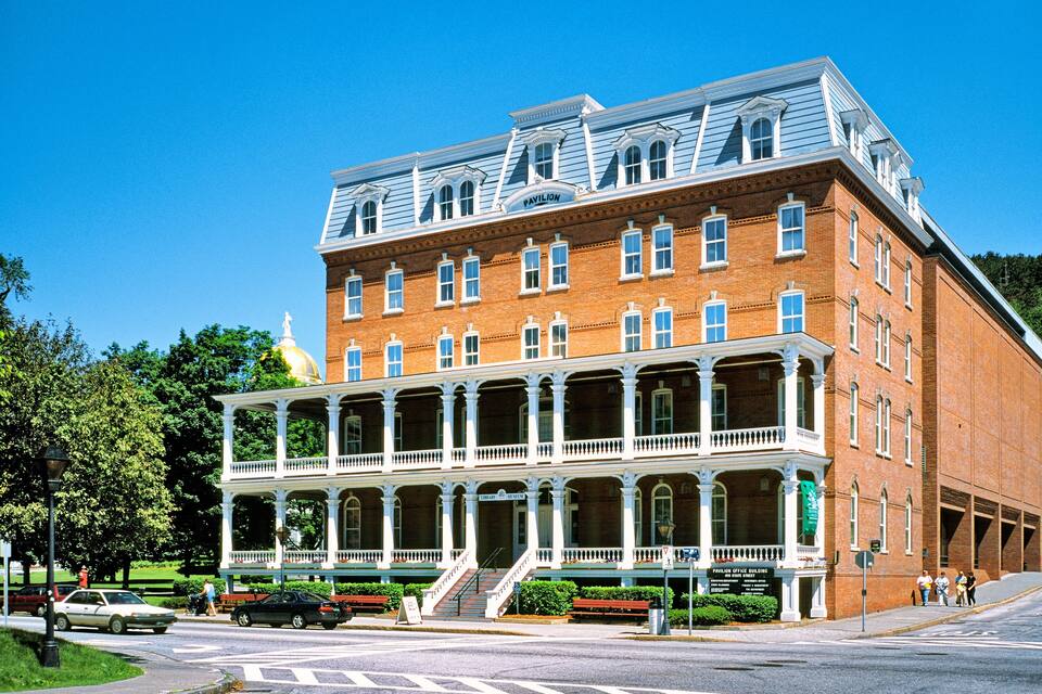 A historic brick building with a large porch and a sign that reads "Pavilion."