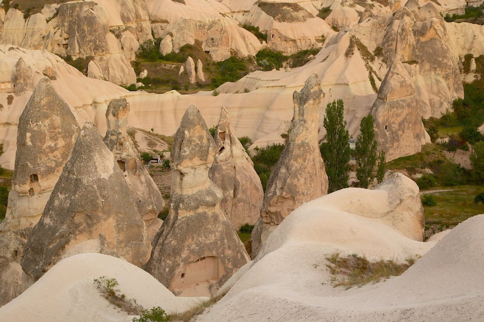 Un paysage caractérisé par des formations rocheuses uniques et la présence de habitations troglodytiques.