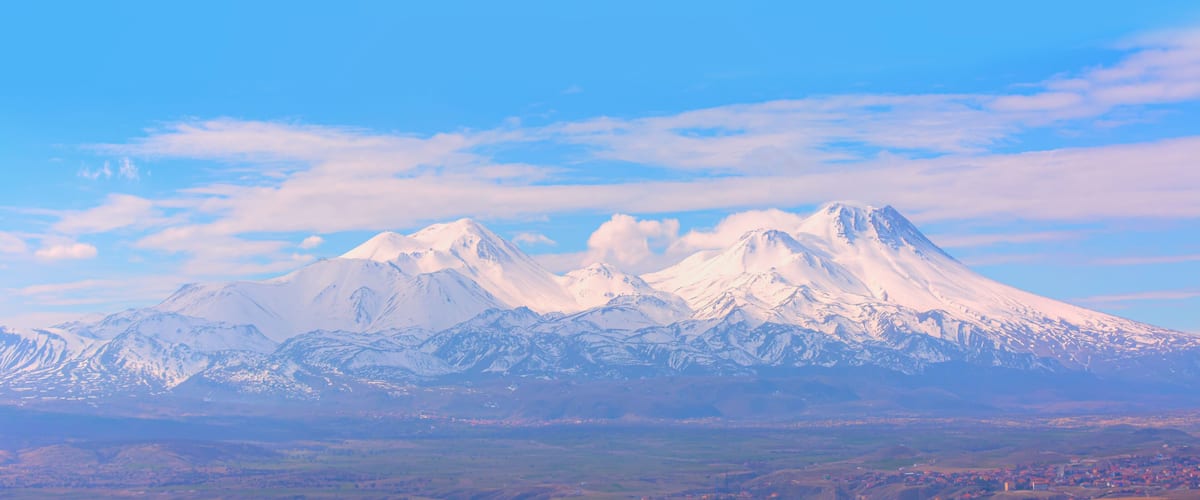 A range of snow-capped mountains with a clear sky above.
