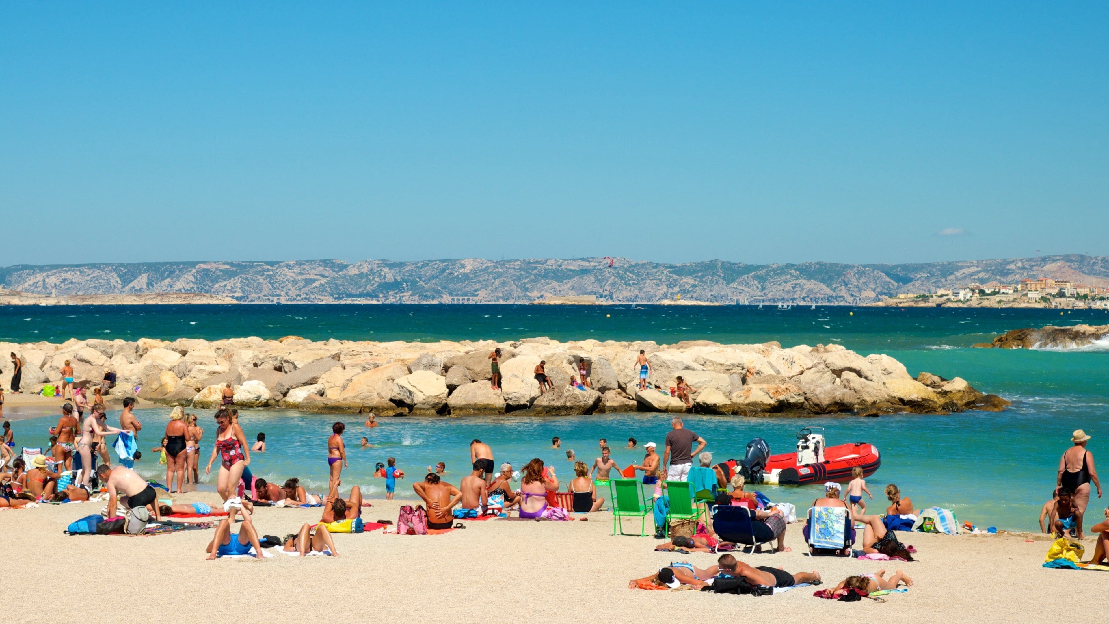 Provence - Alpes - Côte d\'Azur montrant côte rocheuse et plage aussi bien que important groupe de personnes