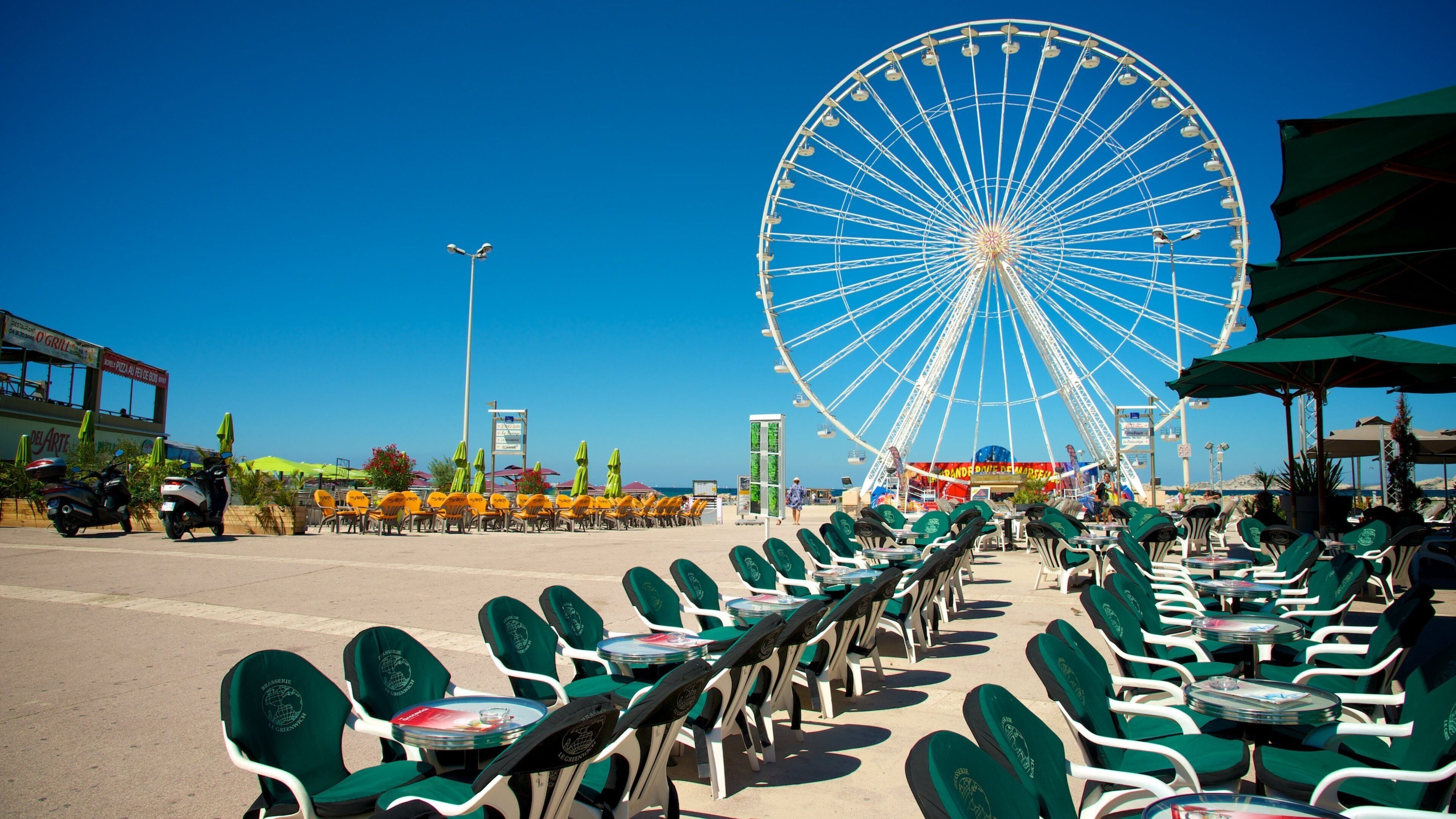 A Ferris wheel, outdoor seating, and a clear blue sky.