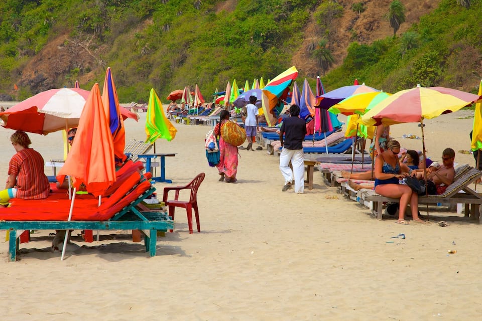 Une plage avec des parasols colorés et des chaises longues.