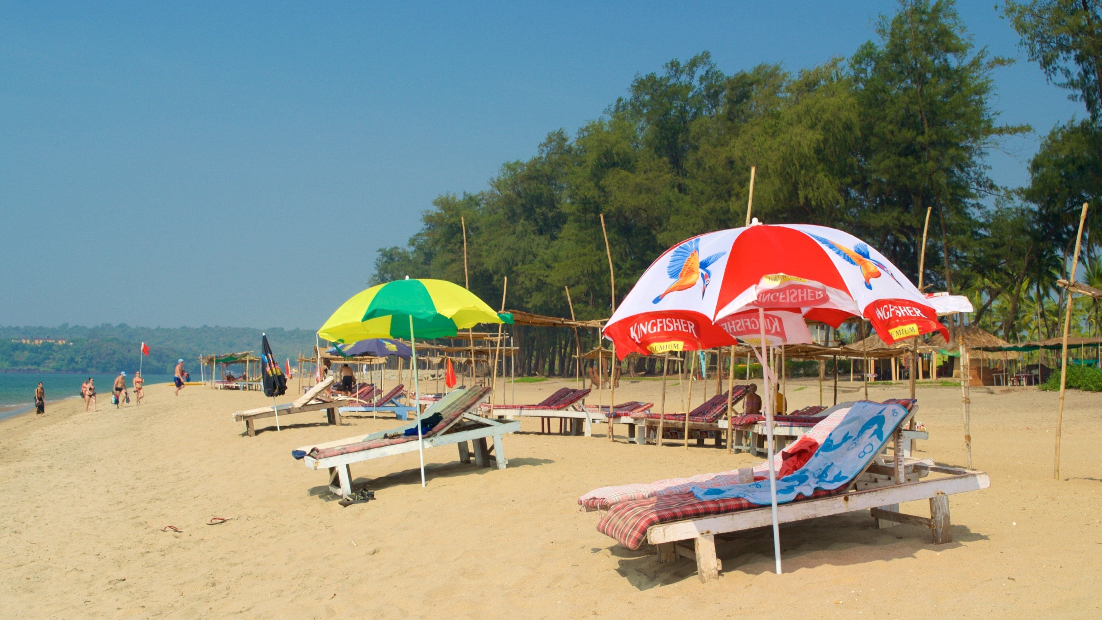 A beach with sun loungers and colorful umbrellas.