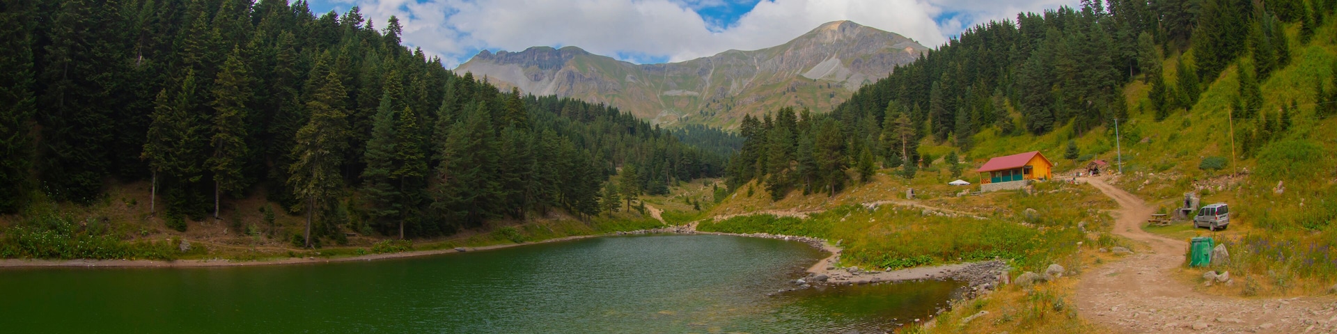 Un lago rodeado de bosque y montañas.